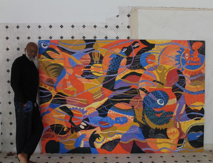 a picture showing moyo okediji standing next to his artwork