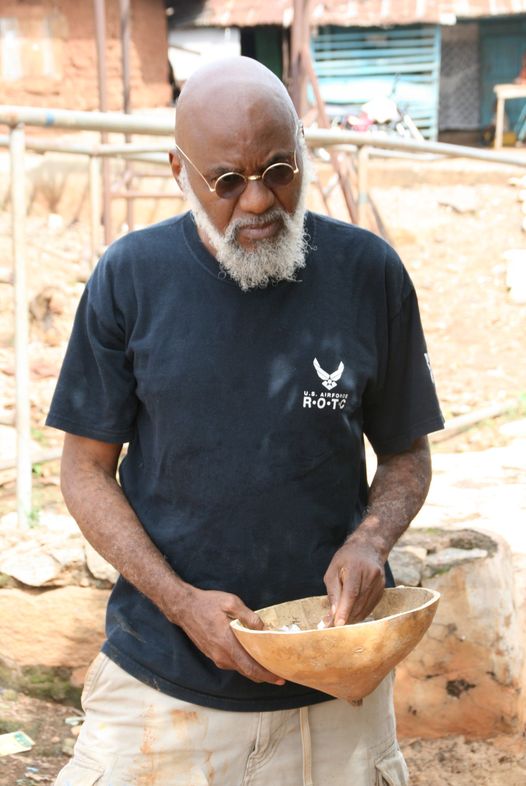 a picture of prof at the akodi orisa holding a calabash