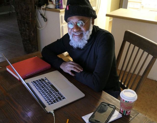 a picture showing moyo okediji working on his pc poised for the camera