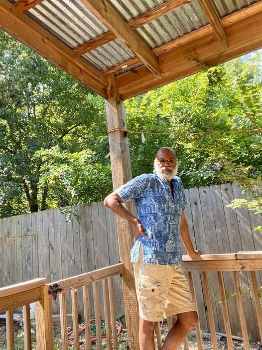 a picture showing moyo okediji poised under a shed for the camera