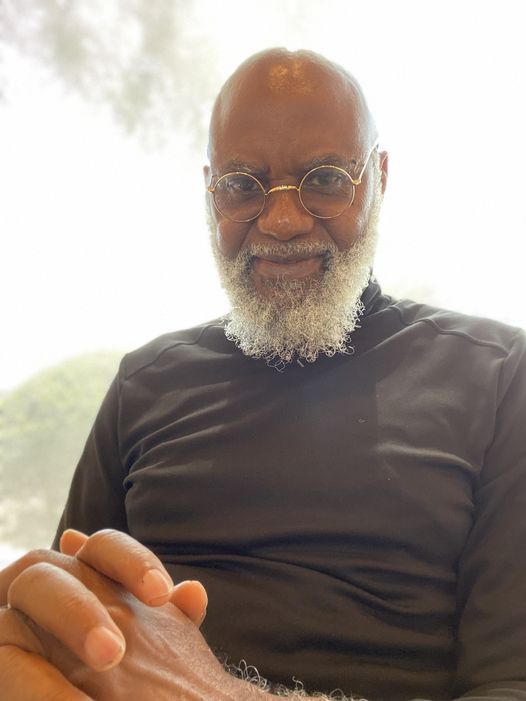 a picture showing moyo okediji poised for the camera and holding a pen