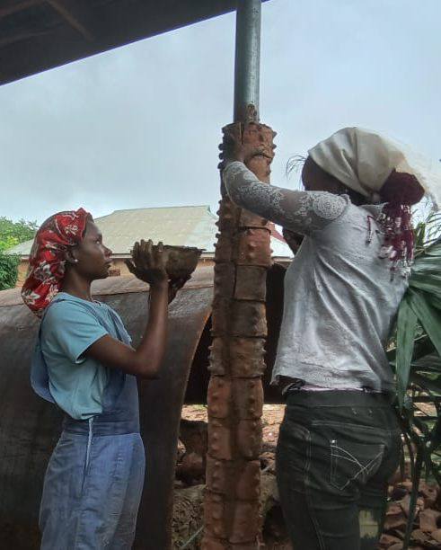 a post by moyo okediji showing the akodi orisa artists working on a pillar