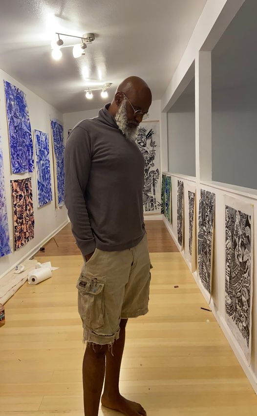 A picture of Moyo Okediji standing and posed for a picture in his art gallery