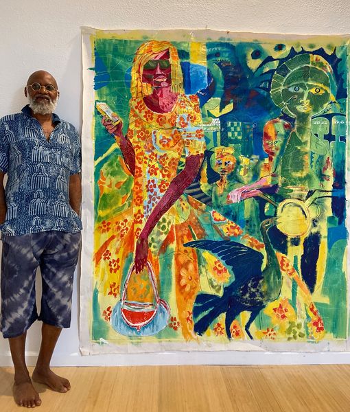 a picture showing moyo okediji standing next to his artwork