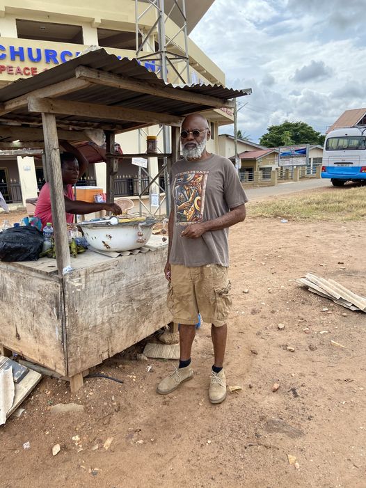 a picture showing moyo okediji standing next to a kiosk