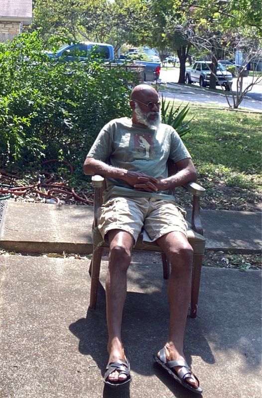 a picture showing moyo okediji sitting on a chair poised for the camera