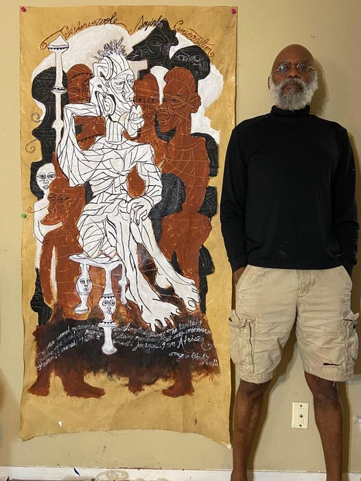 a picture showing moyo okediji standing next to his artwork