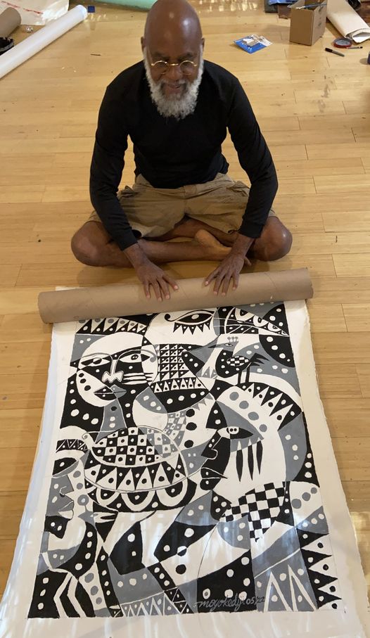 A picture of Moyo Okediji sitting in front of his artwork