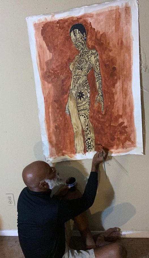 a picture showing moyo okediji working on a art piece