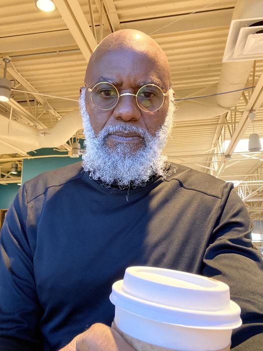 a picture showing moyo okediji sitting and taking a sip of his starbuck